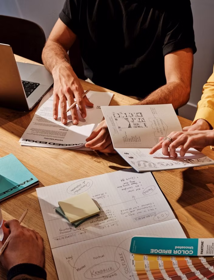 Hands arranging visual research and design materials