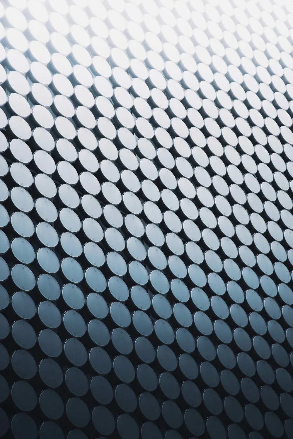 A close, repeating pattern of circular perforations on a curved metal surface.